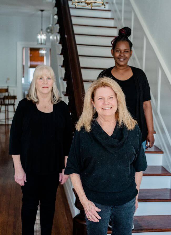 Linda Cooper and 3 staff on stairs